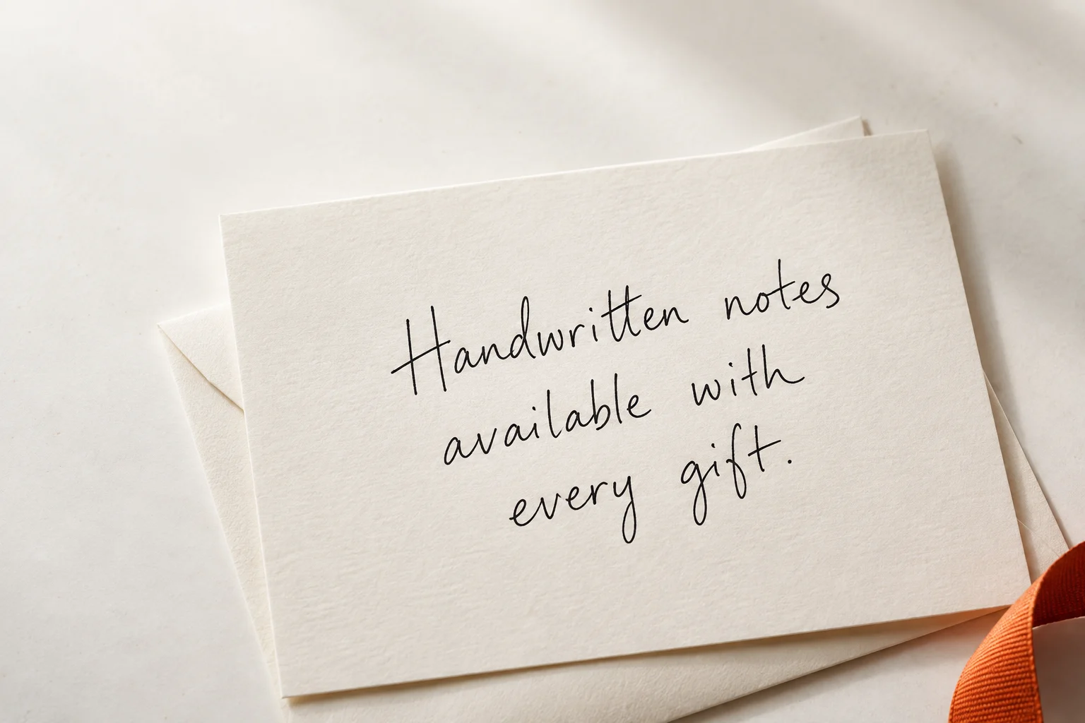 An ivory card with a handwritten message: Handwritten notes available with every gift.